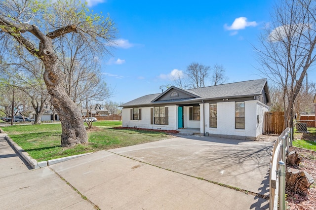 1010 Belew St, Irving, TX 75061 - view of front facade featuring a front lawn, driveway, fence, roof with shingles, and brick siding