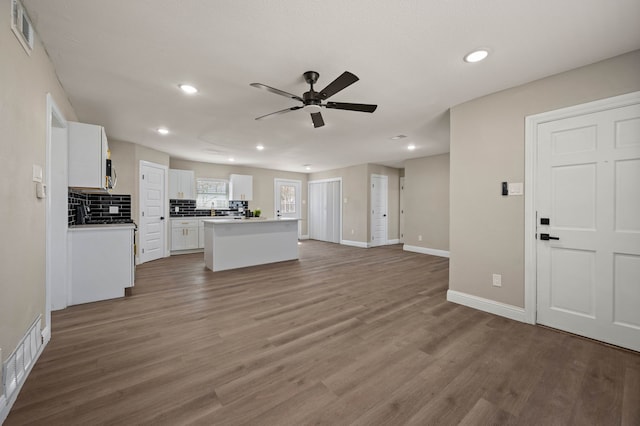 1010 Belew St, Irving, TX 75061 - kitchen with visible vents, wood finished floors, ceiling fan, and white cabinetry