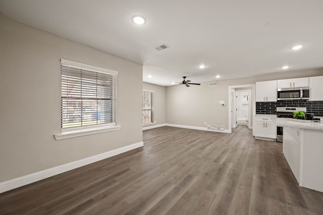 1010 Belew St, Irving, TX 75061 - kitchen with dark wood-type flooring, backsplash, appliances with stainless steel finishes, and white cabinetry