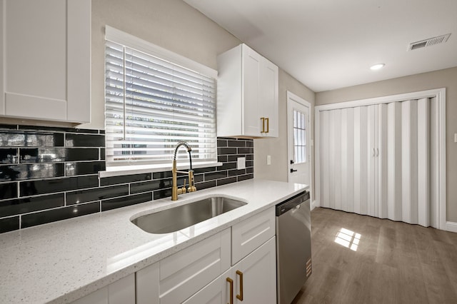 1010 Belew St, Irving, TX 75061 - kitchen with tasteful backsplash, visible vents, dishwasher, white cabinetry, and a sink