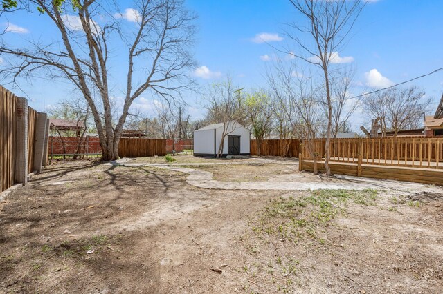 1010 Belew St, Irving, TX 75061 - view of yard with a storage unit, a fenced backyard, an outdoor structure, and a deck