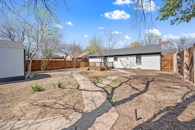 1010 Belew St, Irving, TX 75061 - back of house featuring an outbuilding, a shed, a wooden deck, and a fenced backyard
