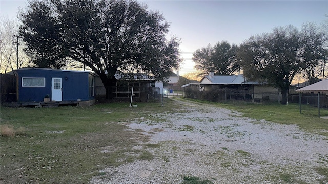 view of yard with an outbuilding, driveway, entry steps, and fence