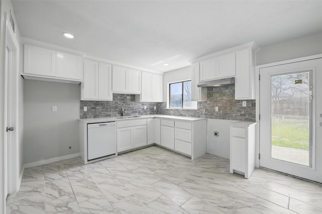 kitchen featuring tasteful backsplash, a sink, dishwasher, marble finish floor, and under cabinet range hood