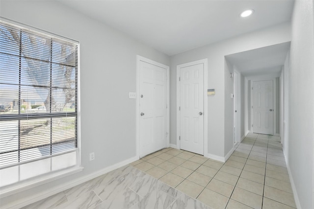 spare room with recessed lighting and baseboards