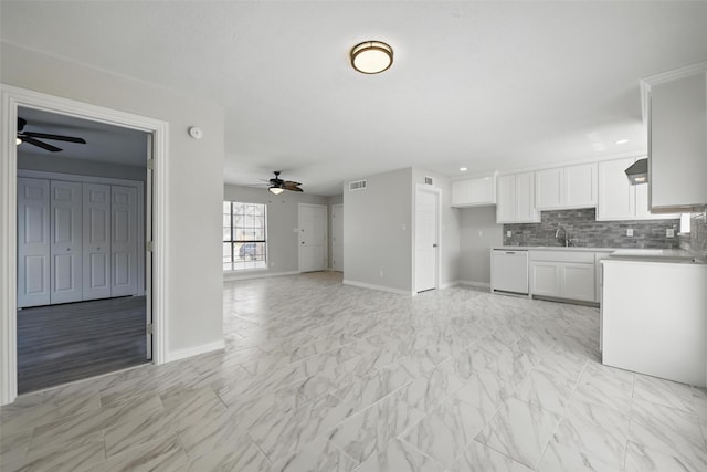 kitchen featuring dishwasher, ceiling fan, baseboards, and white cabinetry