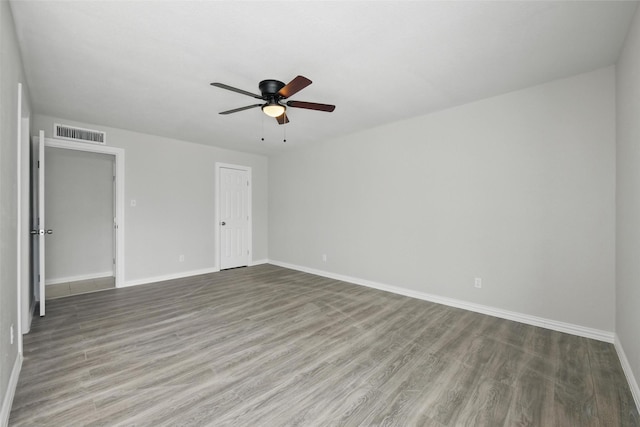 unfurnished bedroom with baseboards, wood finished floors, visible vents, and a ceiling fan