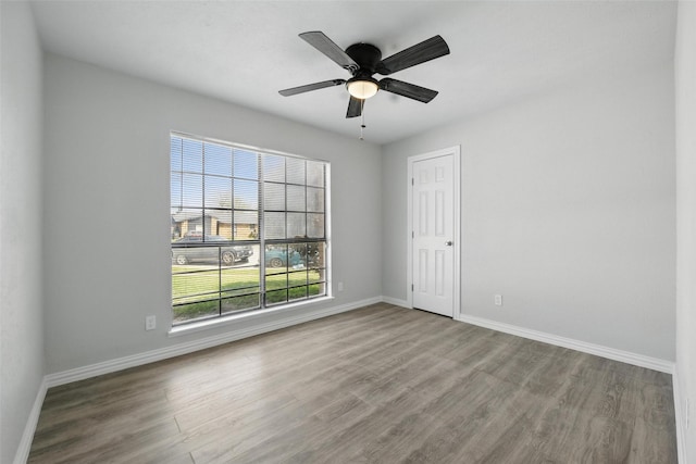 unfurnished room featuring baseboards, a ceiling fan, and wood finished floors