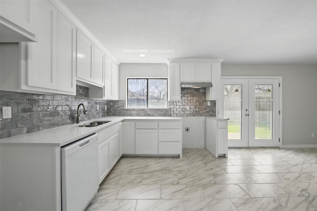 kitchen with a sink, tasteful backsplash, white dishwasher, marble finish floor, and under cabinet range hood