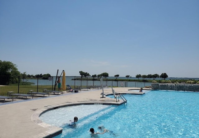 community pool with fence and a patio area
