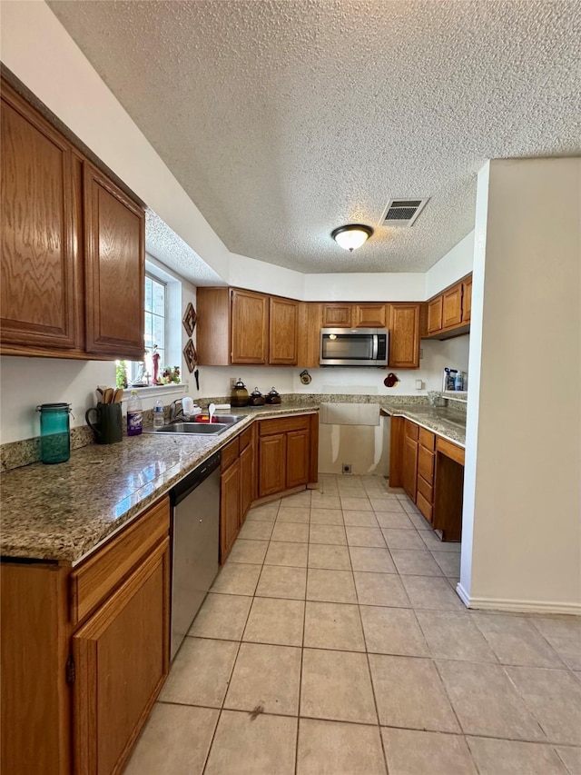 2604 Glenmore Dr, Mesquite, TX 75150 - kitchen featuring visible vents, light tile patterned flooring, a sink, appliances with stainless steel finishes, and brown cabinets