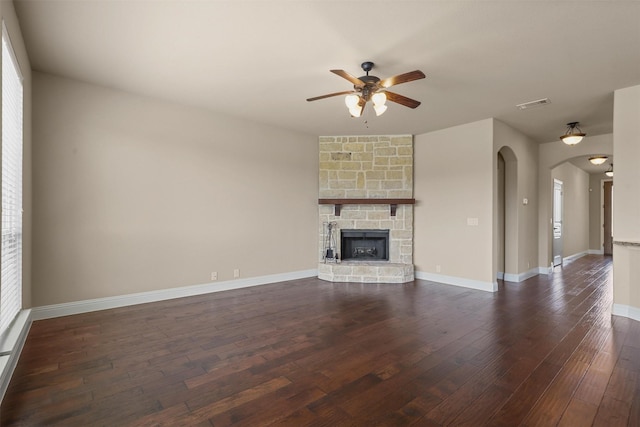 1305 Greenrock Ct, Midlothian, TX 76065 - unfurnished living room with a ceiling fan, arched walkways, dark wood finished floors, a fireplace, and baseboards