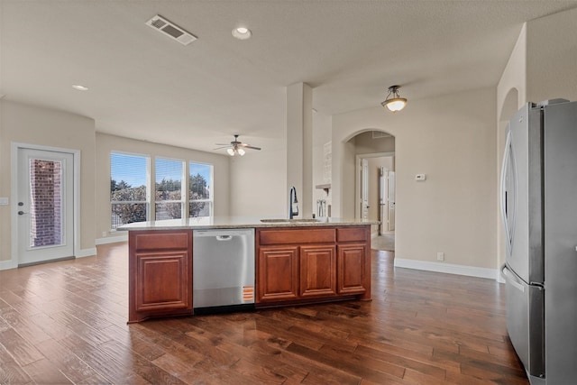 1305 Greenrock Ct, Midlothian, TX 76065 - kitchen featuring stainless steel appliances, a sink, arched walkways, ceiling fan, and dark wood-type flooring