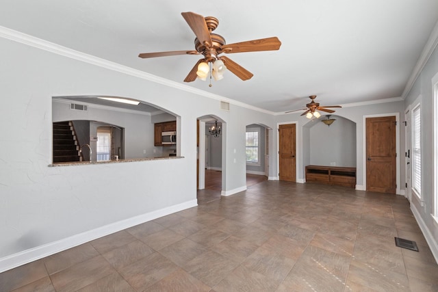 2508 Carnation Ave, Fort Worth, TX 76111 - unfurnished living room featuring a ceiling fan, baseboards, ornamental molding, and arched walkways
