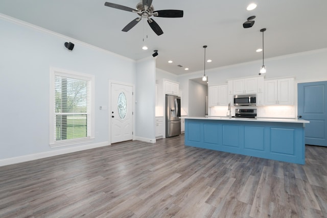 kitchen featuring white cabinets, ornamental molding, a ceiling fan, and appliances with stainless steel finishes