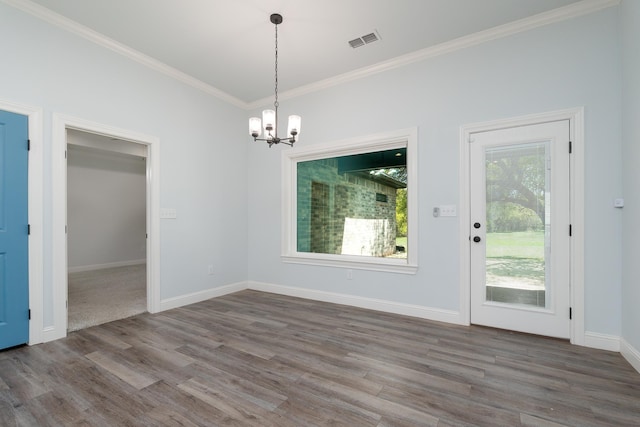 unfurnished dining area featuring ornamental molding, a notable chandelier, visible vents, and wood finished floors