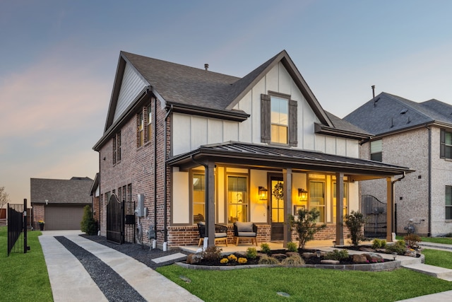 view of front of home with an outdoor structure, a standing seam roof, board and batten siding, brick siding, and a porch