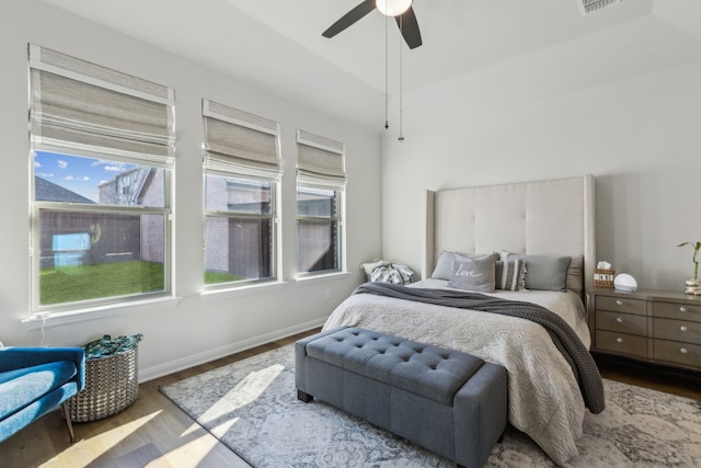 bedroom with visible vents, baseboards, ceiling fan, and wood finished floors