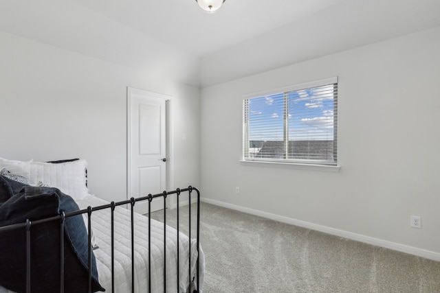 bedroom featuring baseboards, carpet flooring, and vaulted ceiling