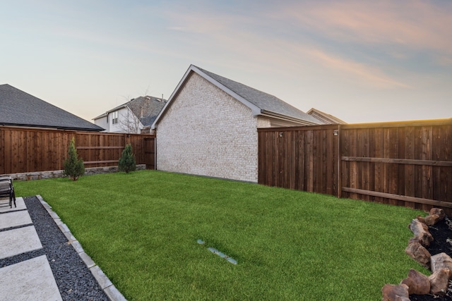 yard at dusk with a fenced backyard