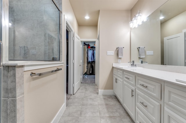 2624 El Camino Ln, Dallas, TX 75212 - full bathroom featuring tiled shower, vanity, a spacious closet, and baseboards