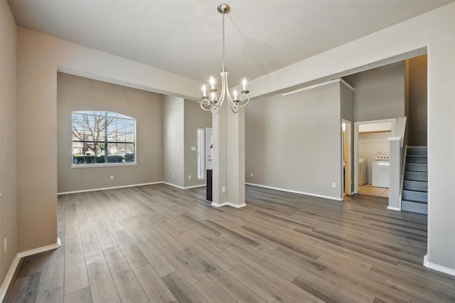 804 Starling Ln, Aubrey, TX 76227 - spare room with washer / dryer, a chandelier, wood finished floors, stairs, and baseboards