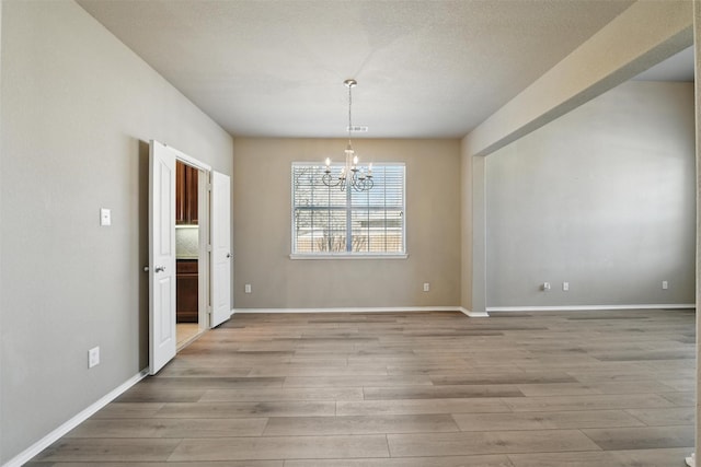 804 Starling Ln, Aubrey, TX 76227 - unfurnished dining area with a chandelier, light wood-style floors, and baseboards