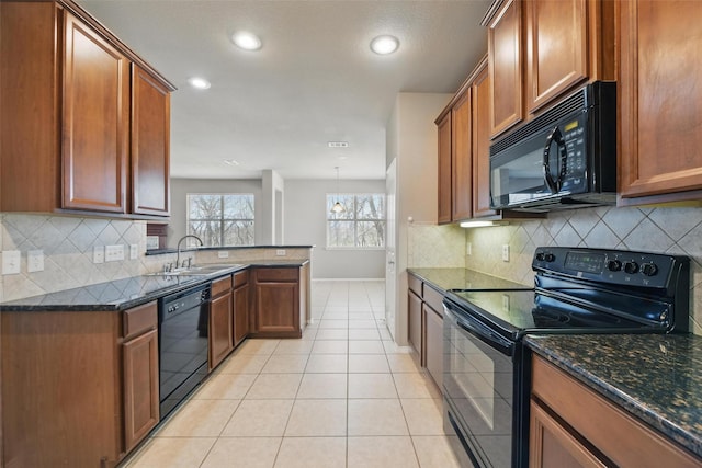 804 Starling Ln, Aubrey, TX 76227 - kitchen with black appliances, a sink, light tile patterned floors, dark stone counters, and brown cabinetry