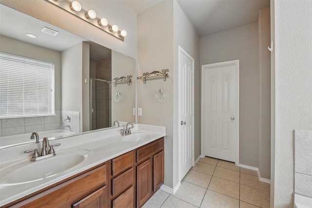 804 Starling Ln, Aubrey, TX 76227 - bathroom featuring tile patterned floors, double vanity, a garden tub, an enclosed shower, and baseboards