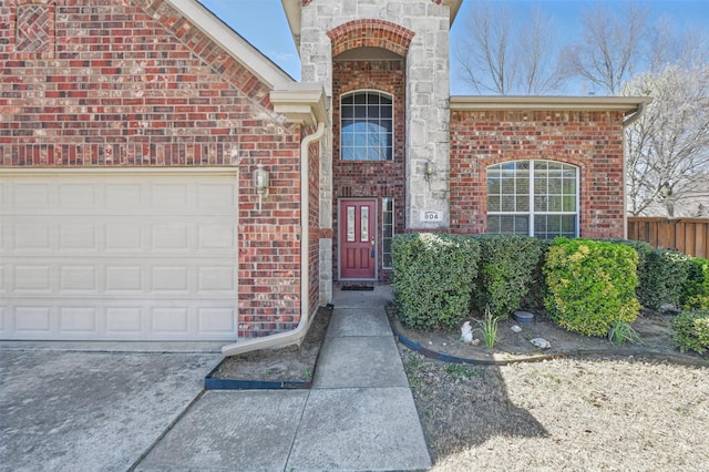 804 Starling Ln, Aubrey, TX 76227 - view of exterior entry with brick siding, driveway, and a garage