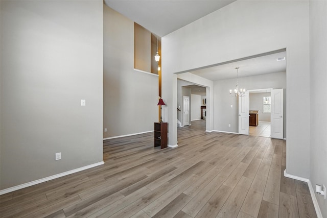 804 Starling Ln, Aubrey, TX 76227 - unfurnished living room featuring light wood-style flooring, a chandelier, and baseboards