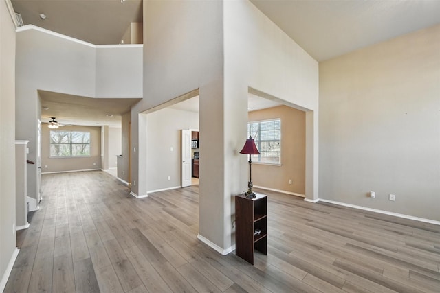 804 Starling Ln, Aubrey, TX 76227 - unfurnished living room with a high ceiling, wood finished floors, baseboards, stairway, and a ceiling fan