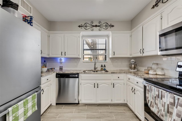 702 Middle Glen Dr, Garland, TX 75043 - kitchen with a sink, appliances with stainless steel finishes, and white cabinetry
