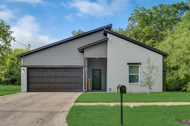 mid-century modern home with concrete driveway, a garage, brick siding, and a front yard