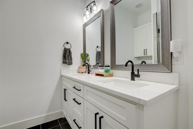 bathroom with a sink, visible vents, double vanity, and tile patterned flooring
