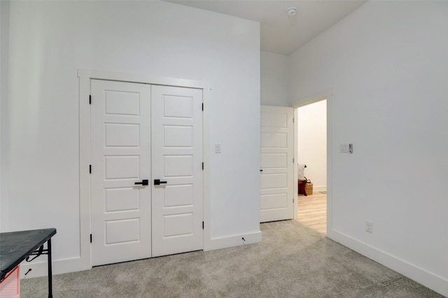 unfurnished bedroom with carpet flooring, baseboards, and a closet