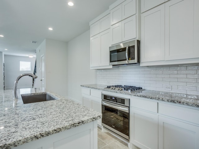 6519 Bowman Roberts Dr, Fort Worth, TX 76179 - kitchen with visible vents, decorative backsplash, appliances with stainless steel finishes, white cabinets, and a sink