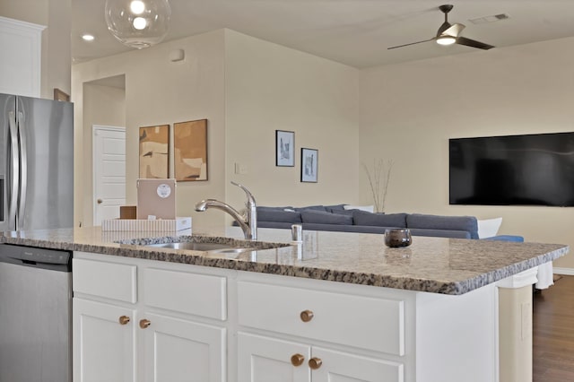 kitchen featuring a ceiling fan, visible vents, a sink, stainless steel appliances, and open floor plan