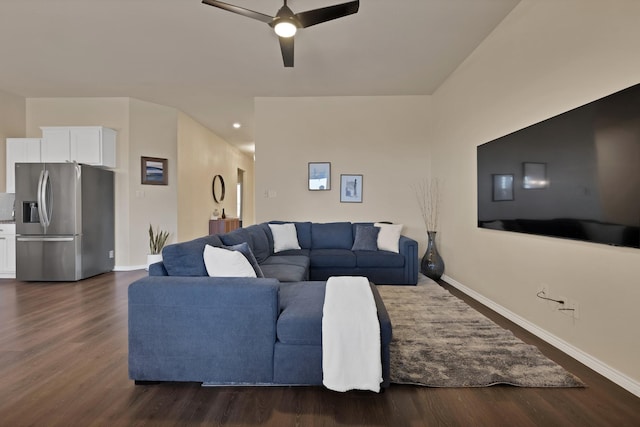 living room featuring baseboards, dark wood-type flooring, and a ceiling fan