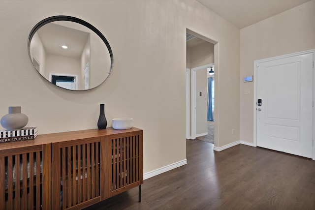 foyer with baseboards and wood finished floors