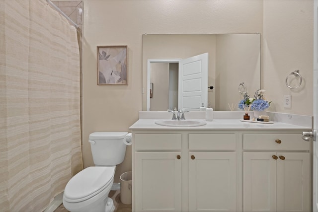 bathroom featuring toilet, vanity, and a shower with curtain