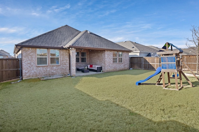 rear view of property with brick siding, a playground, roof with shingles, a fenced backyard, and a patio area