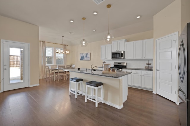 kitchen with tasteful backsplash, appliances with stainless steel finishes, dark wood-type flooring, and a sink