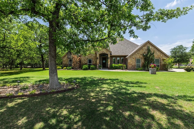 view of front facade with a front lawn and stone siding