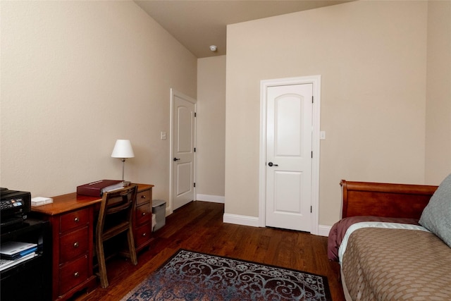 bedroom featuring baseboards and dark wood-style floors