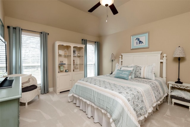 bedroom featuring baseboards, ceiling fan, vaulted ceiling, and light carpet