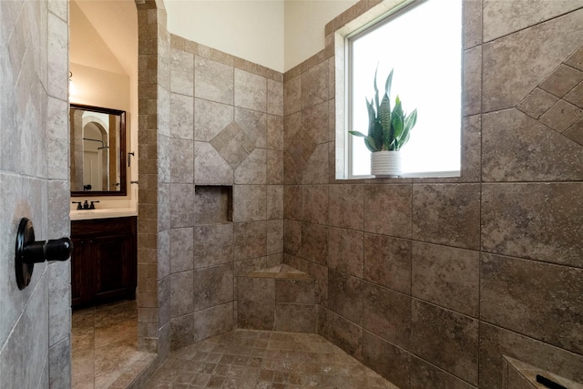 bathroom featuring tiled shower, a wealth of natural light, and vanity