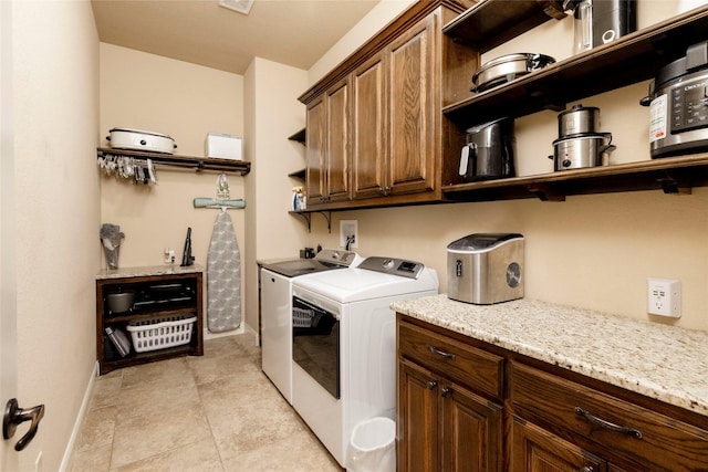 clothes washing area with baseboards, cabinet space, washer and dryer, and visible vents