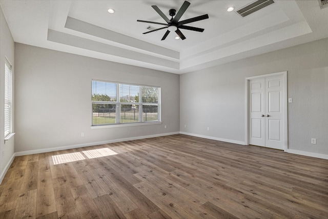 111 Sharla Smelley Rd, Weatherford, TX 76088 - spare room with a tray ceiling, wood finished floors, ceiling fan, baseboards, and recessed lighting