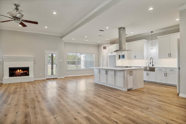 111 Sharla Smelley Rd, Weatherford, TX 76088 - kitchen featuring island range hood, open floor plan, a sink, white cabinets, and recessed lighting
